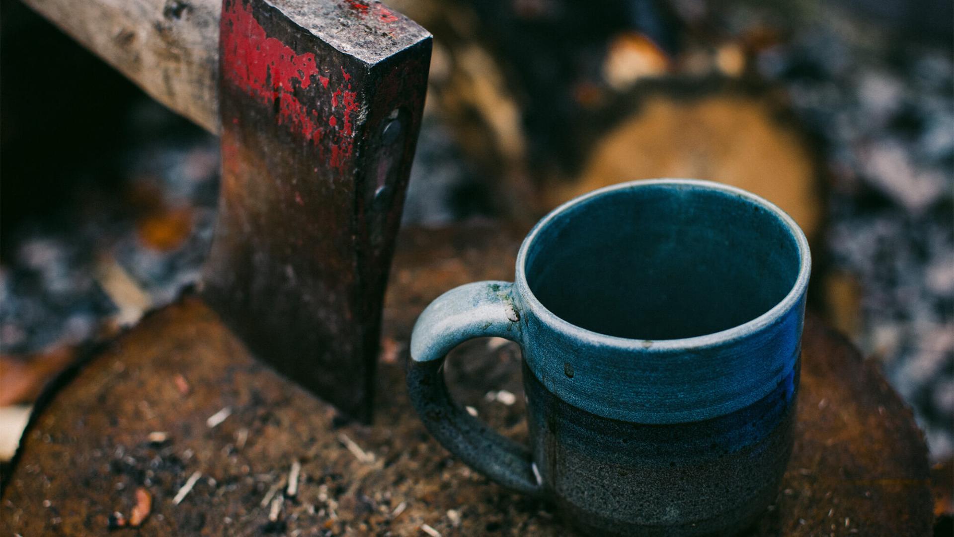 Enamel cup and a rusty axe