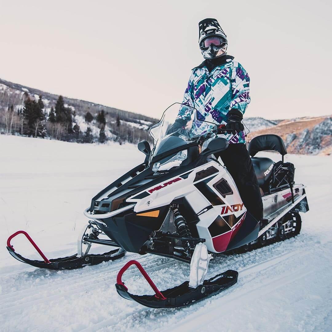 Man standing on top of snowmobile