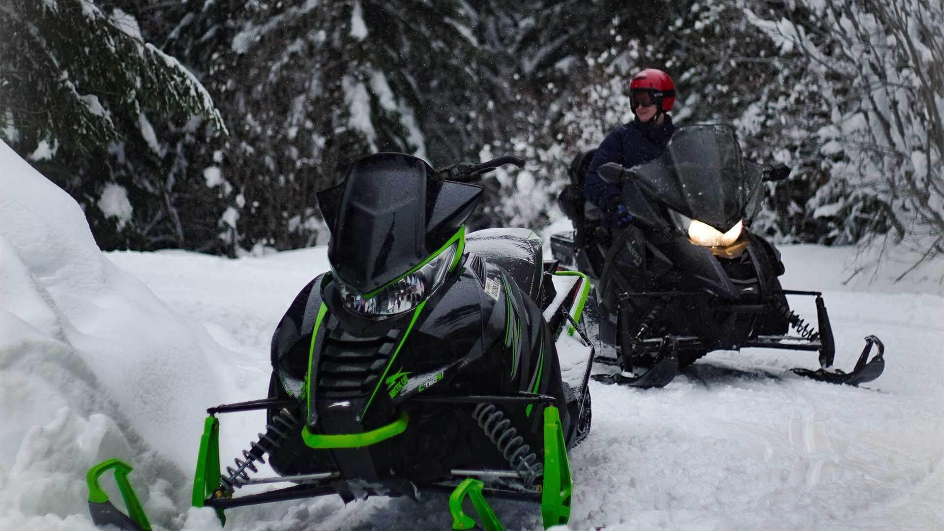 Parked snowmobiles with accumulating snow