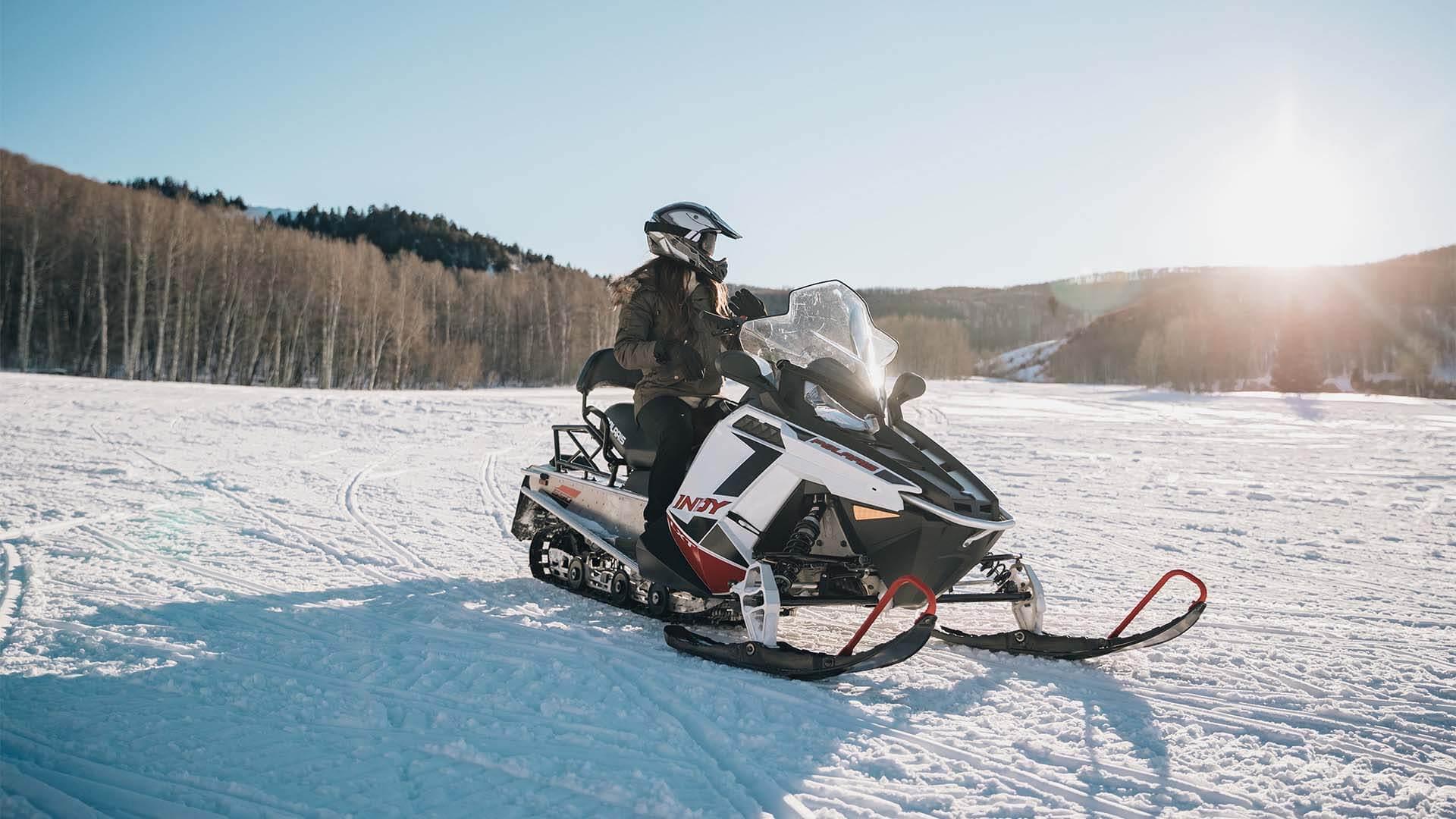 Woman riding a snowmobile on a sunny day