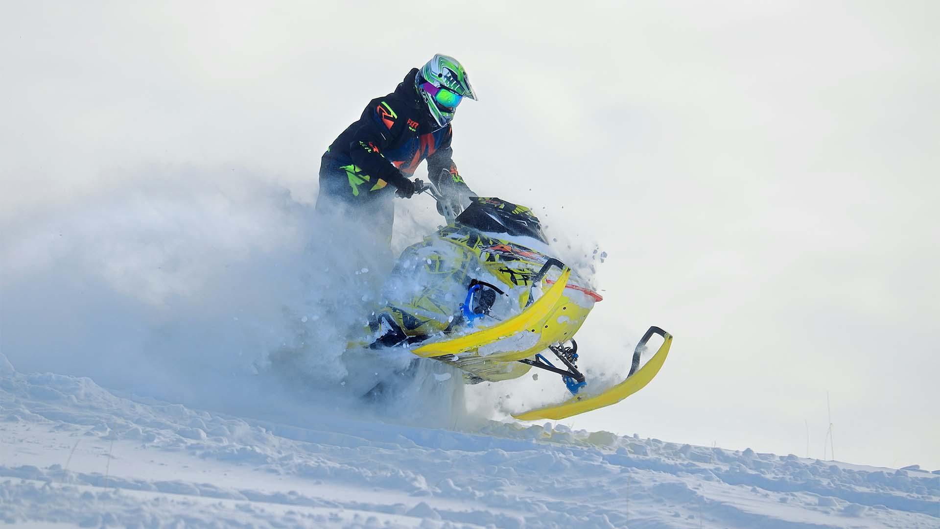 Snowmobile kicking up snow.