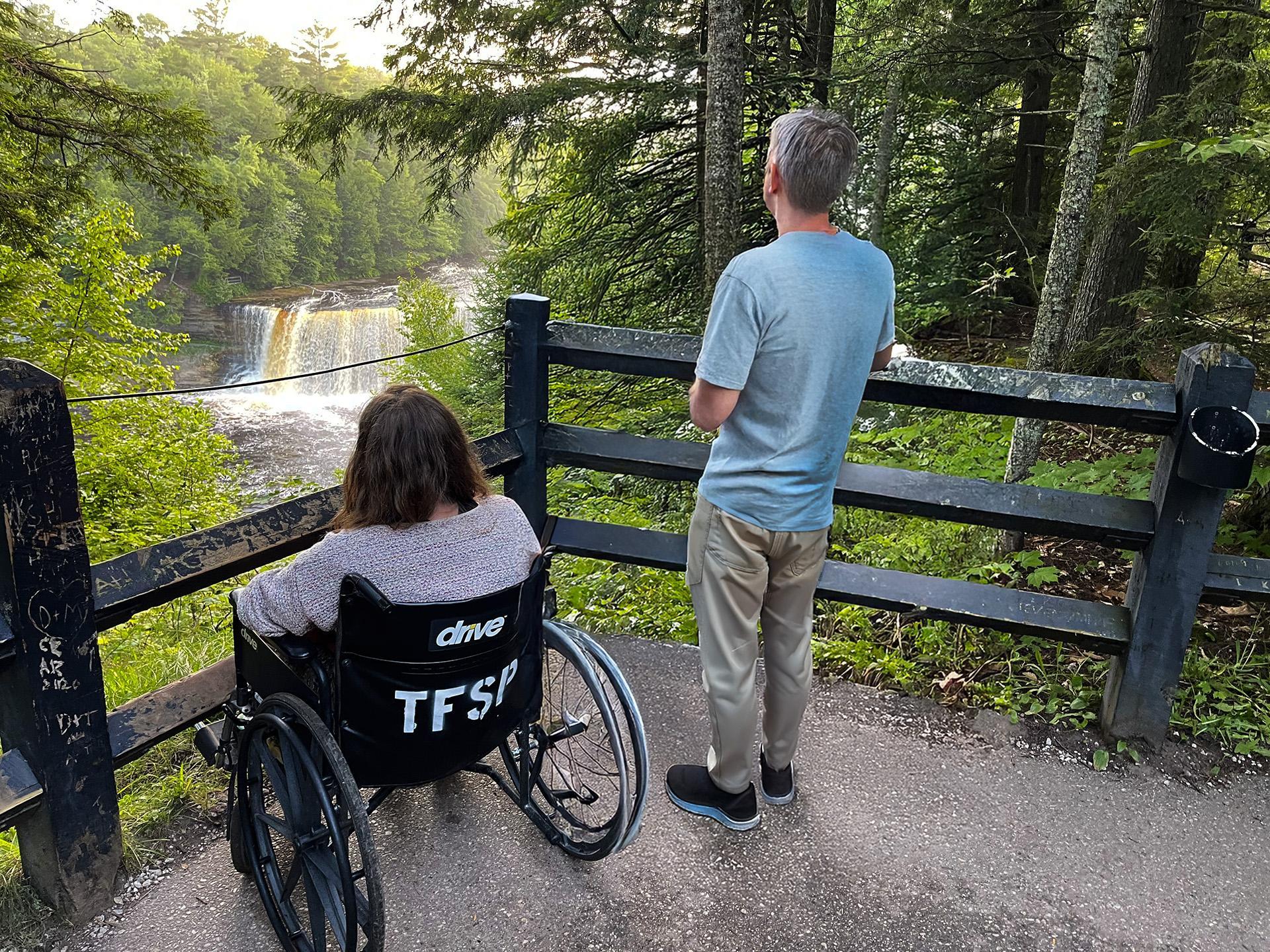 A woman in a wheelchair and her companion take in the view at Tahquamenon Falls Upper Falls.