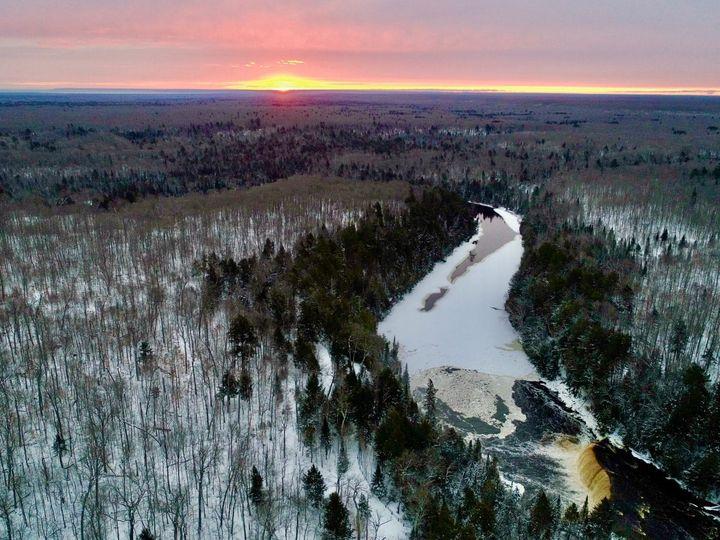 drone shot of sunrise over tahquamenon river